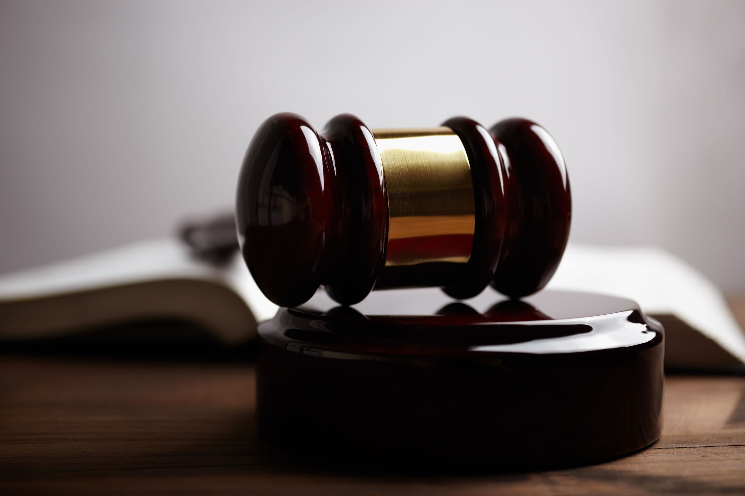 A close up photo of a gavel laying on top of a gavel block